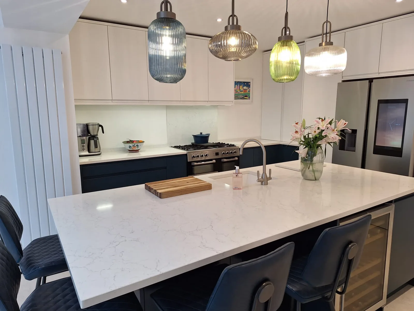 Cream kitchen extension with white marble island and ribbed glass pendants