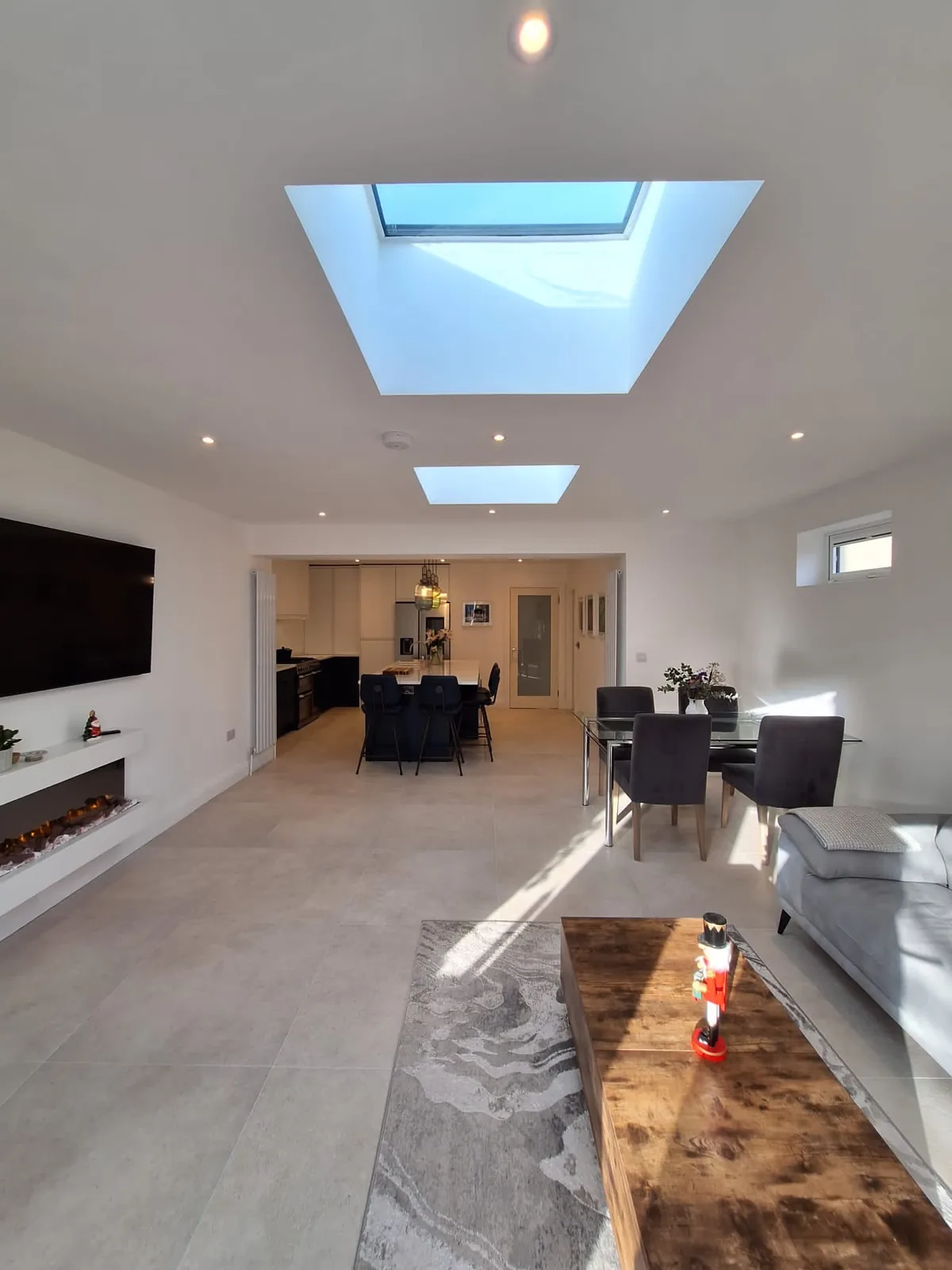 Open-plan living and dining extension with twin skylights and fireplace
