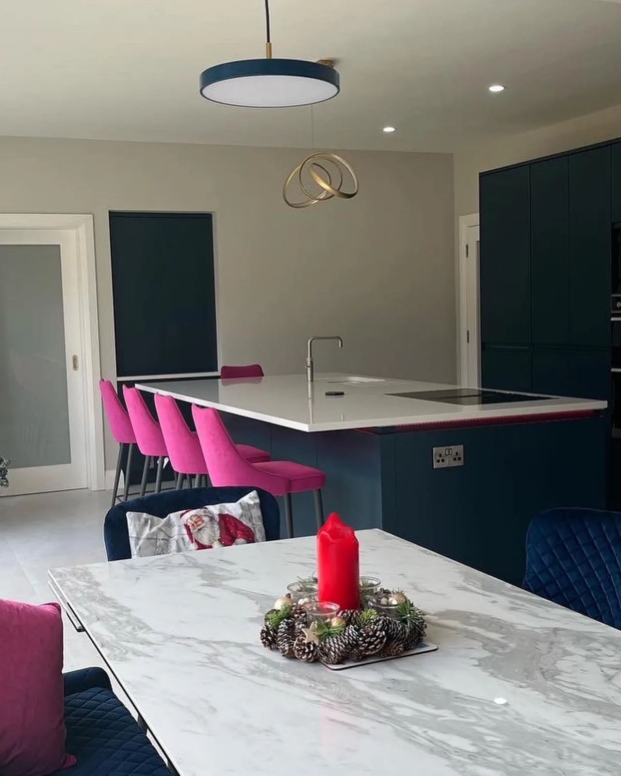 Navy kitchen-diner with pink velvet stools and marble dining table